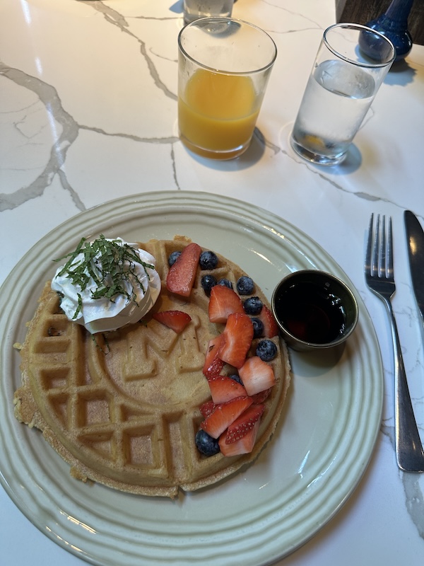A waffle with strawberries and whipped cream